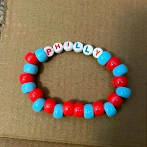 Red and blue plastic beads with letters that spell out Philly and elastic string